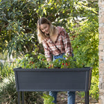 Happy gardener planting veges in raised garden bed