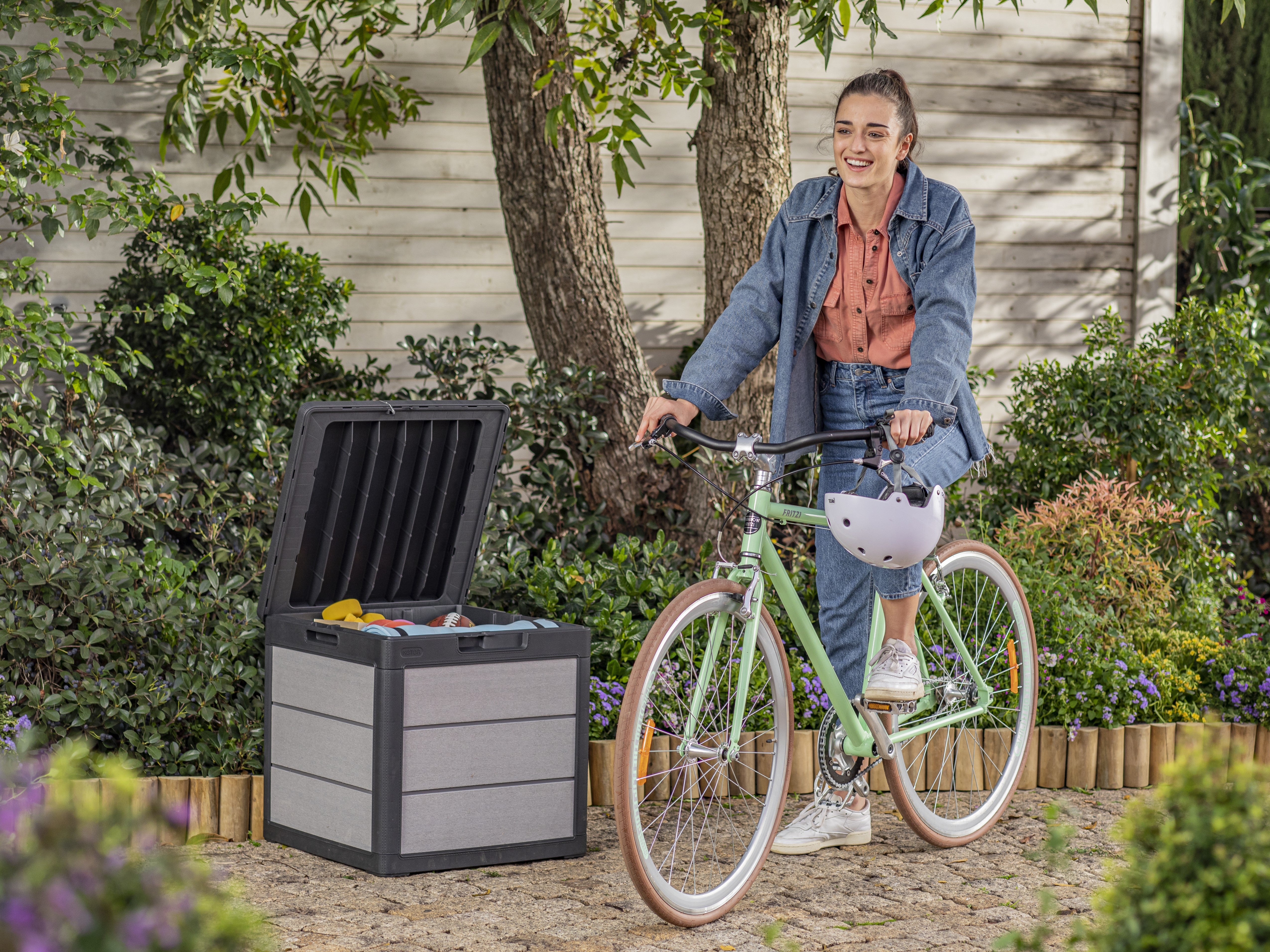 Woman sitting on a bike with the storage box filled with toys
