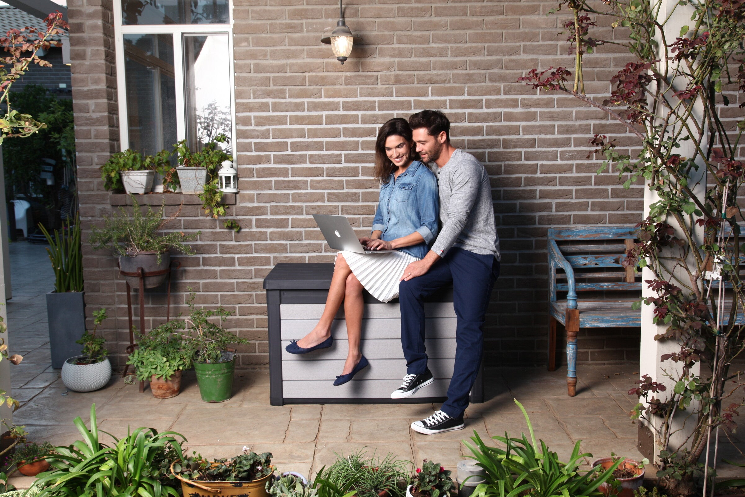 A couple sitting on the lid of the Denali cushion box