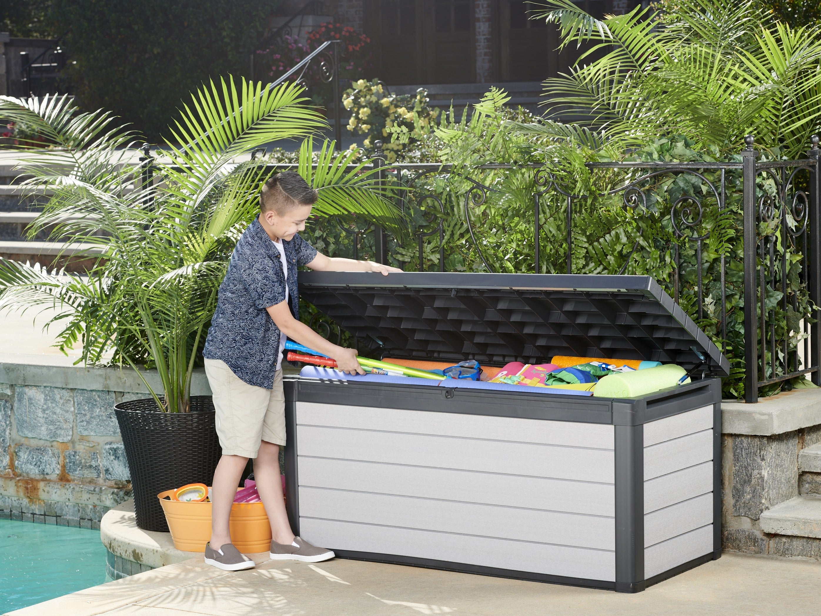 A child getting pool toys out of the Denali Storage box