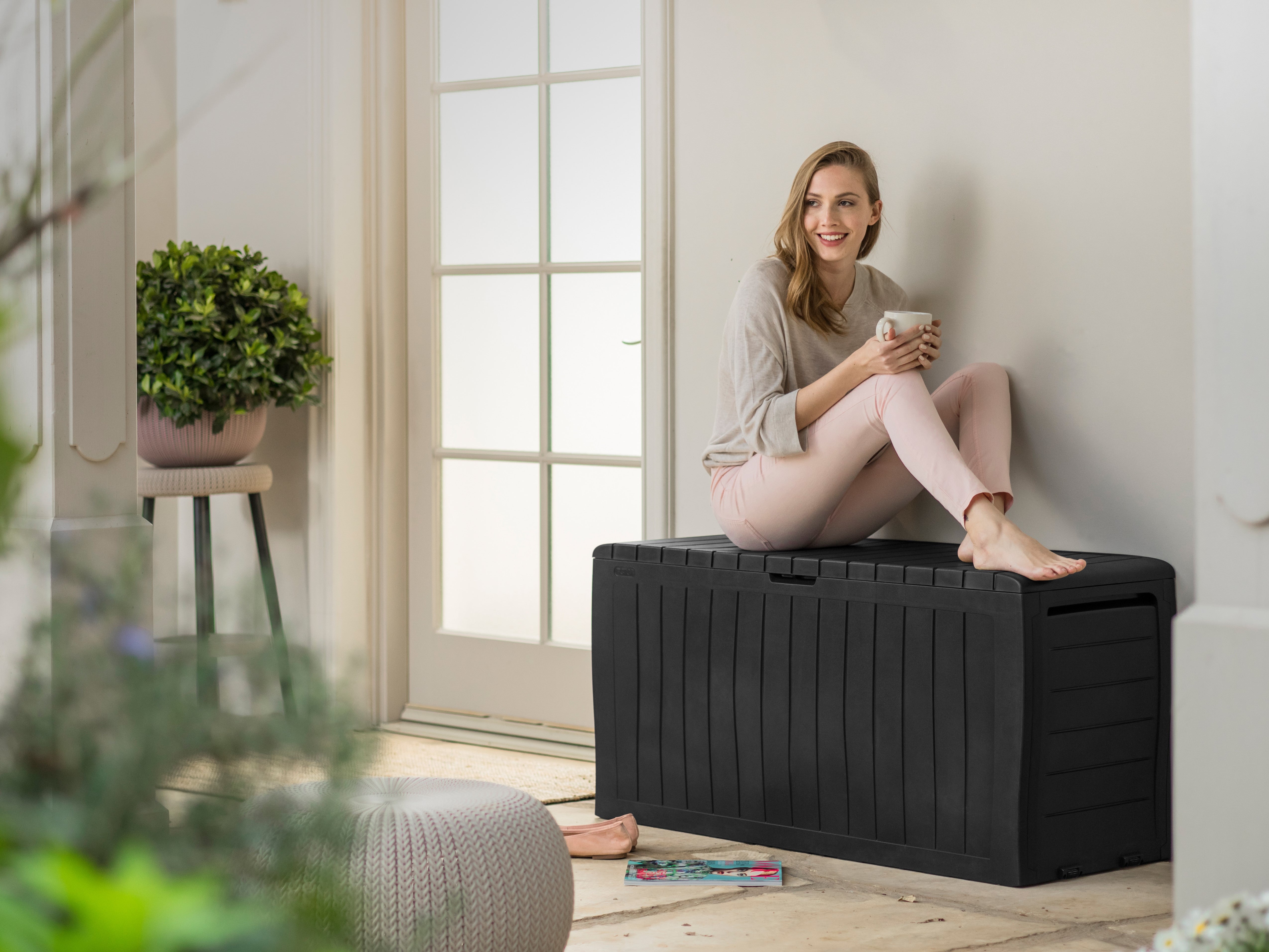 Keter Marvel storage box with woman sitting on lid