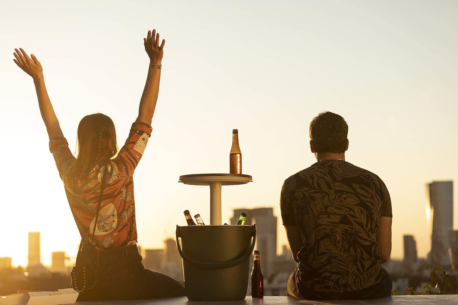 A couple enjoying the Go Bar chilly bin with city backdrop