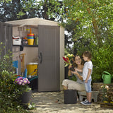 A woman potting plants in front of the factor 6x6 Shed