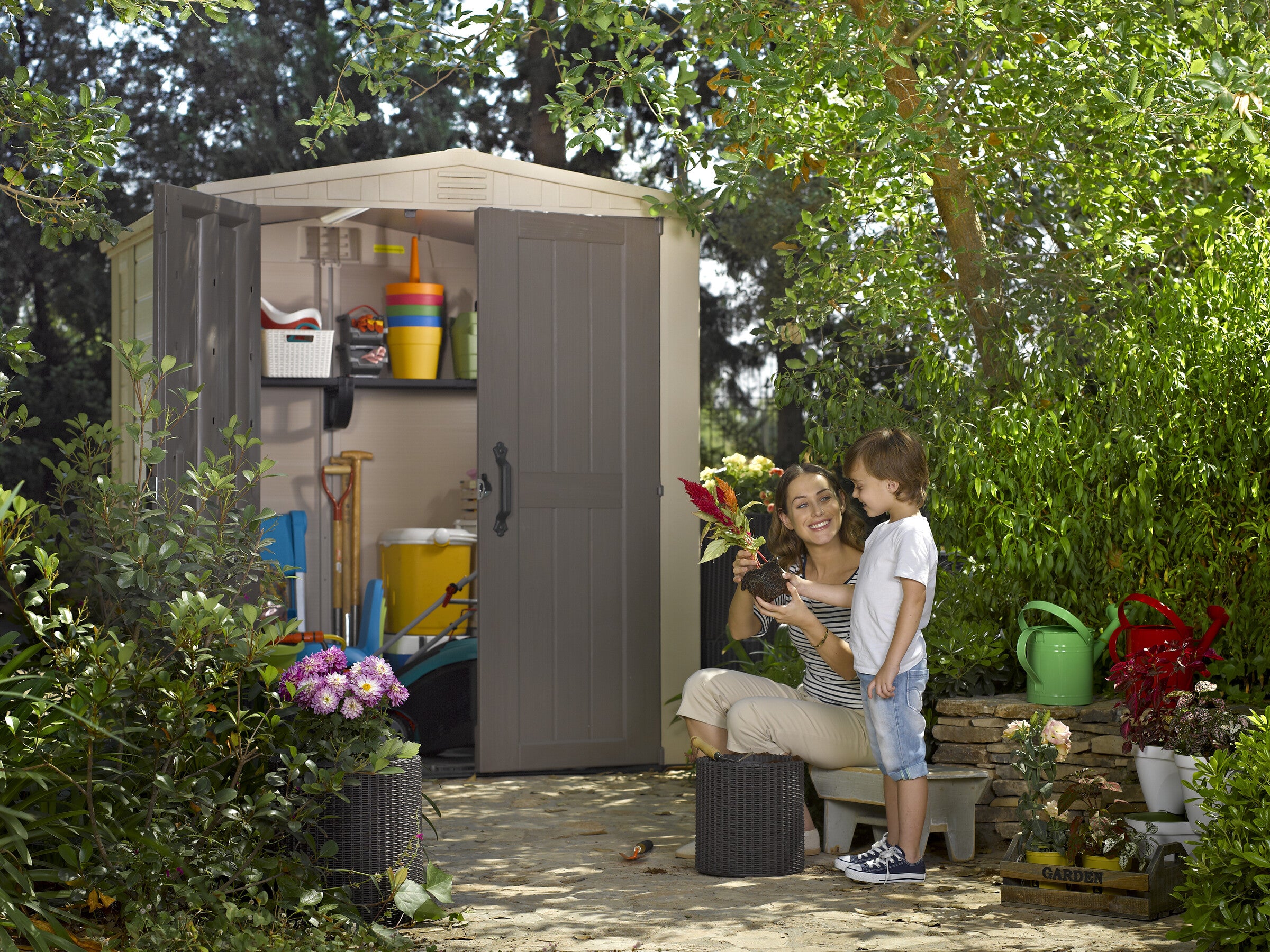 A woman potting plants in front of the factor 6x6 Shed